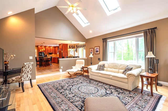 16 Gilboa Ln, Nashua, NH 03062 - living room with a skylight, high vaulted ceiling, ceiling fan, light wood-type flooring, and baseboards