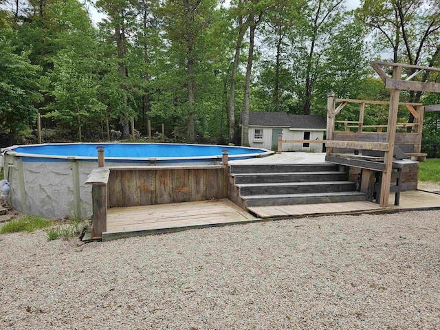 436 Mammoth Rd, Pelham, NH 03076 - swimming pool with an outbuilding, a wooden deck, and view of wooded area