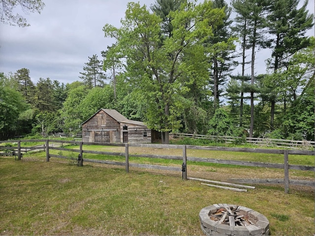 436 Mammoth Rd, Pelham, NH 03076 - view of yard with a barn, an outdoor fire pit, an outbuilding, and a wooded view