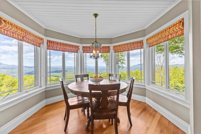 1097 Taber Ridge Rd, Stowe, VT 05672 - sunroom / solarium with baseboards, wood-type flooring, crown molding, a chandelier, and a mountain view