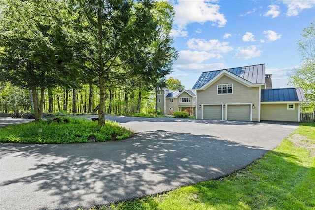 1097 Taber Ridge Rd, Stowe, VT 05672 - view of front of house with a standing seam roof, driveway, metal roof, and an attached garage