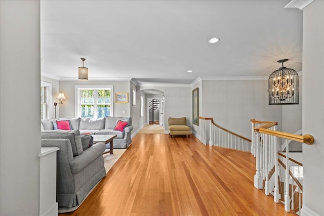 1097 Taber Ridge Rd, Stowe, VT 05672 - living room with arched walkways, light wood-style flooring, ornamental molding, recessed lighting, and a chandelier