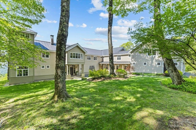 1097 Taber Ridge Rd, Stowe, VT 05672 - rear view of house featuring a standing seam roof, a yard, and metal roof