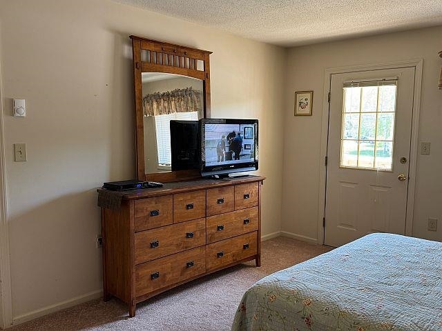 227 Main St Unit 232, Lincoln, NH 03251 - bedroom featuring light colored carpet, baseboards, and a textured ceiling