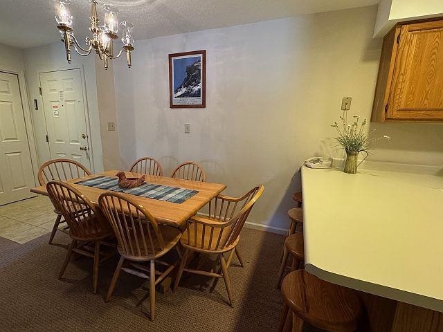 227 Main St Unit 232, Lincoln, NH 03251 - dining area with a chandelier and a textured ceiling