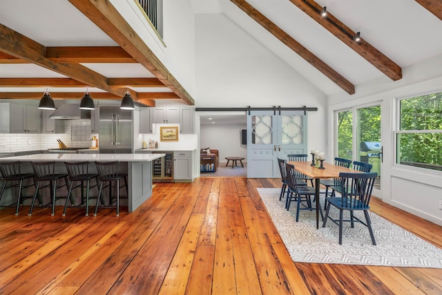 47 Hollow View Rd, Stowe, VT 05672 - dining area with light wood-style floors, beamed ceiling, high vaulted ceiling, beverage cooler, and track lighting