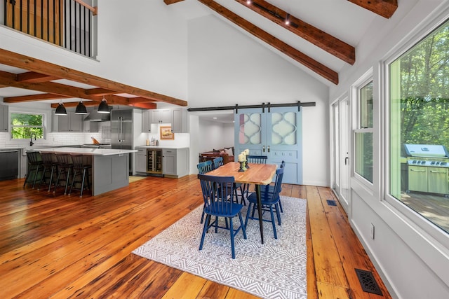 47 Hollow View Rd, Stowe, VT 05672 - dining room with beamed ceiling, light wood finished floors, high vaulted ceiling, wine cooler, and healthy amount of natural light