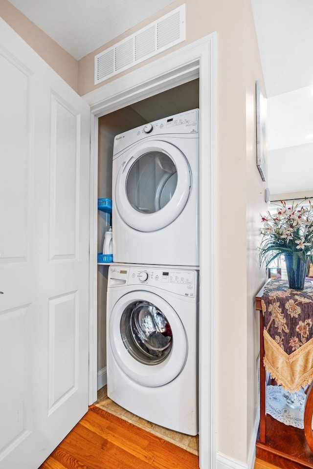 7 Elystan Cir, Nashua, NH 03064 - laundry area with stacked washing machine and dryer and wood finished floors