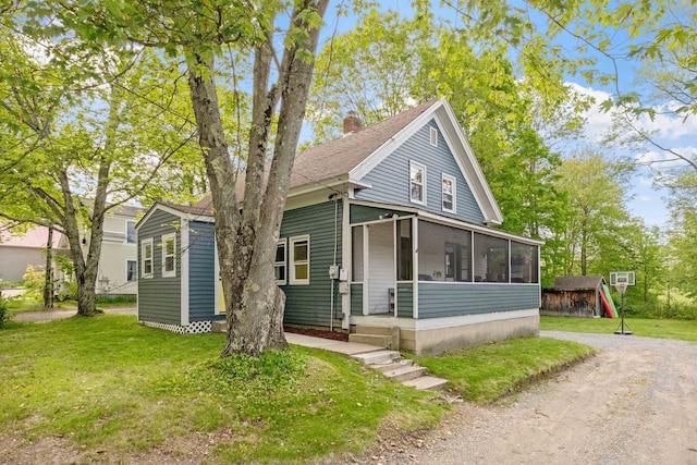 194 Pleasant St, Bristol, NH 03222 - view of front of property with a sunroom, a chimney, a front yard, and an outdoor structure