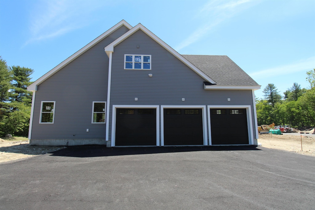21 Cornstalk Ln, Pelham, NH 03076 - view of side of home with asphalt driveway and an attached garage