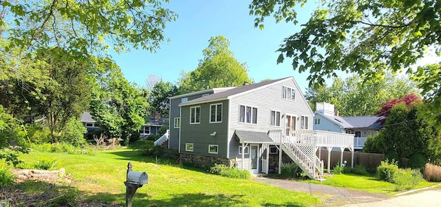 21 Triton Dr, Rye, NH 03870 - rear view of house with stairway, a lawn, stone siding, and a wooden deck