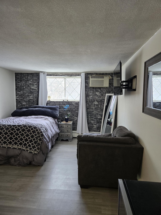 2 Silvestri Cir Unit 6, Derry, NH 03038 - bedroom with a textured ceiling, wood finished floors, and a wall unit AC
