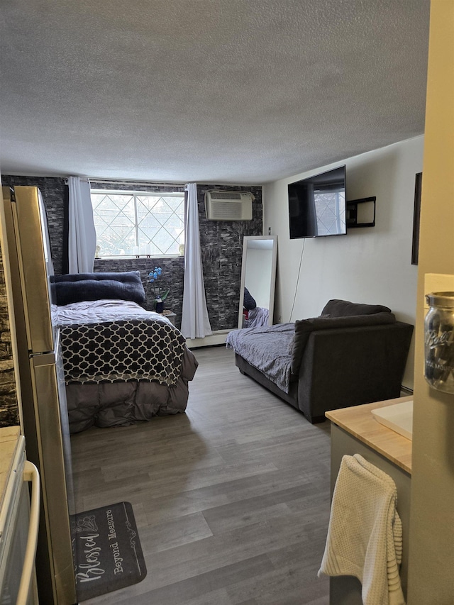 2 Silvestri Cir Unit 6, Derry, NH 03038 - bedroom featuring a wall unit AC, a textured ceiling, and wood finished floors