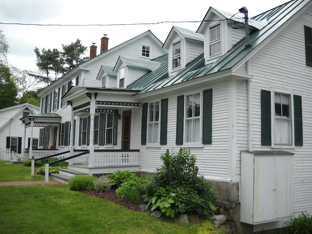 6 On The Cmn Unit 5, Lyme, NH 03768 - view of side of property featuring a metal roof, a standing seam roof, a lawn, a chimney, and a porch