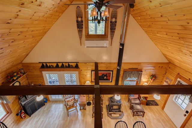 3233 Stinson Lake Rd, Ellsworth, NH 03266 - living area featuring ceiling fan, a wall mounted AC, wood walls, wood finished floors, and wood ceiling