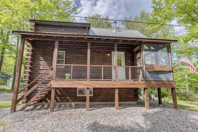 3233 Stinson Lake Rd, Ellsworth, NH 03266 - back of property with a sunroom, log siding, metal roof, and stairs