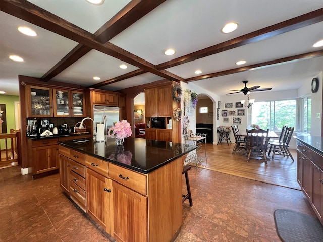 6 Nightingale Ln, Grantham, NH 03753 - kitchen with arched walkways, stainless steel fridge with ice dispenser, beamed ceiling, a center island with sink, and glass insert cabinets