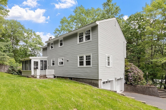 5 Christian Dr, Nashua, NH 03063 - rear view of house featuring a sunroom, an attached garage, a chimney, and a lawn