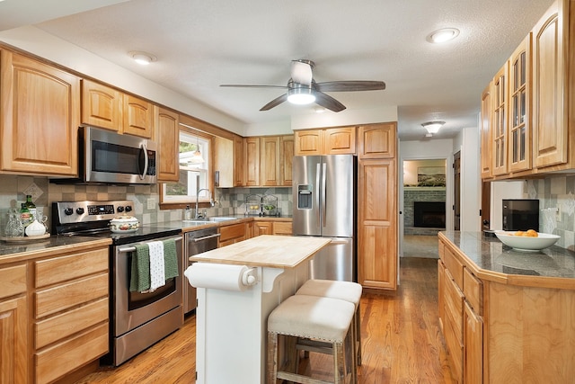 5 Christian Dr, Nashua, NH 03063 - kitchen featuring appliances with stainless steel finishes, light wood-type flooring, glass insert cabinets, and a ceiling fan