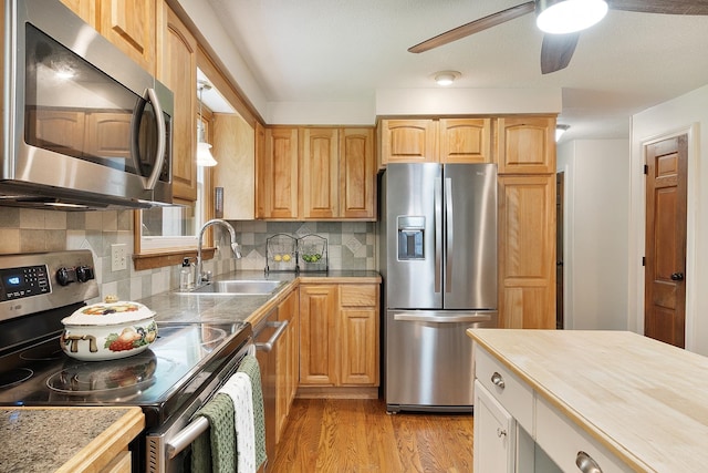 5 Christian Dr, Nashua, NH 03063 - kitchen with stainless steel appliances, a sink, light wood-type flooring, a ceiling fan, and decorative backsplash