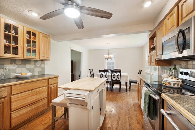 5 Christian Dr, Nashua, NH 03063 - kitchen with stainless steel appliances, tasteful backsplash, glass insert cabinets, and light wood finished floors