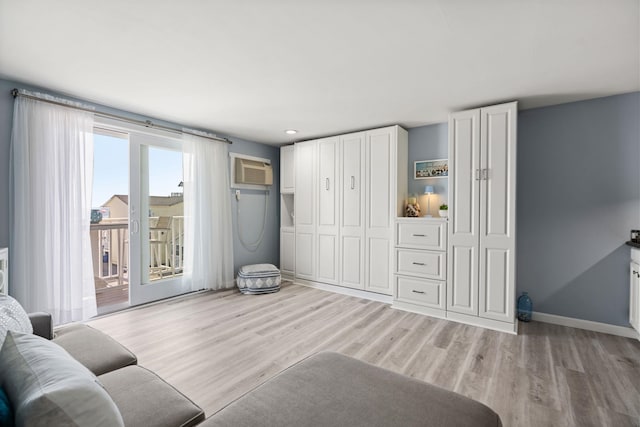 415 Ocean Blvd Unit 2B, Hampton, NH 03842 - living room with an AC wall unit, light wood-style floors, and baseboards
