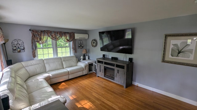 144 Bradford Rd, Henniker, NH 03242 - living room with a wall unit AC, wood finished floors, and baseboards