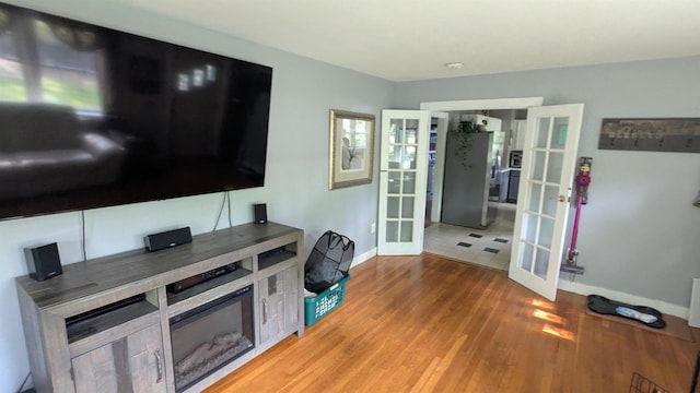 144 Bradford Rd, Henniker, NH 03242 - living room with french doors, baseboards, and light wood finished floors