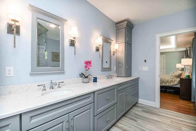 12 Haywick Dr, Stratham, NH 03870 - ensuite bathroom featuring double vanity, wood finished floors, and baseboards
