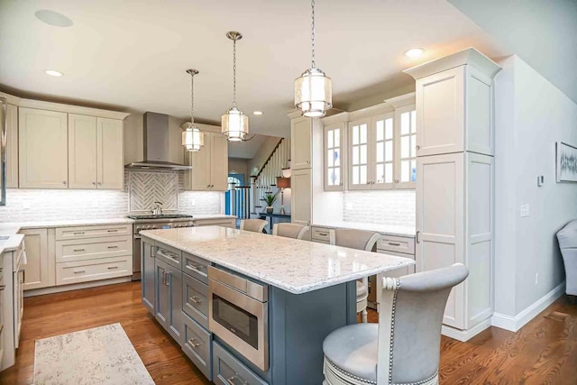 12 Haywick Dr, Stratham, NH 03870 - kitchen featuring wall chimney exhaust hood, stainless steel appliances, a kitchen bar, a center island, and backsplash