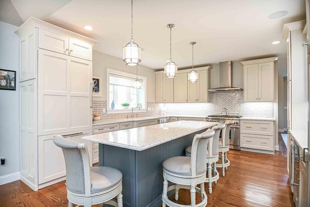 12 Haywick Dr, Stratham, NH 03870 - kitchen with wall chimney exhaust hood, high end stainless steel range, a center island, dark wood-style floors, and a breakfast bar