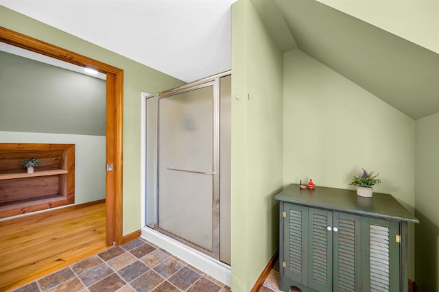 354 Jenny Davis Rd, Waterbury, VT 05676 - bathroom featuring lofted ceiling, a shower stall, stone finish flooring, and baseboards