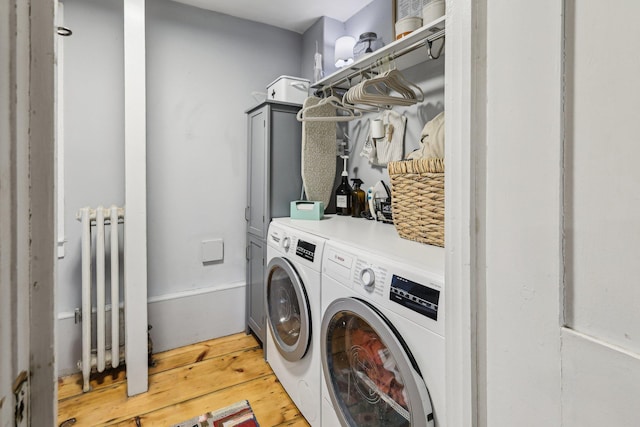 26 Middle St, Amherst, NH 03031 - laundry room with washer and clothes dryer, radiator, light wood finished floors, and cabinet space