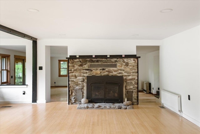 135 Governor Peck Rd, Jericho, VT 05465 - detailed view of radiator heating unit, wood finished floors, a stone fireplace, and baseboards