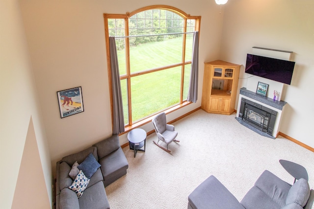 275 Petit Rd, Coventry, VT 05825 - living room featuring baseboards, a fireplace with flush hearth, carpet, and plenty of natural light