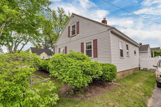 190 Anthony St, Manchester, NH 03103 - view of side of home with a chimney and a vegetable garden