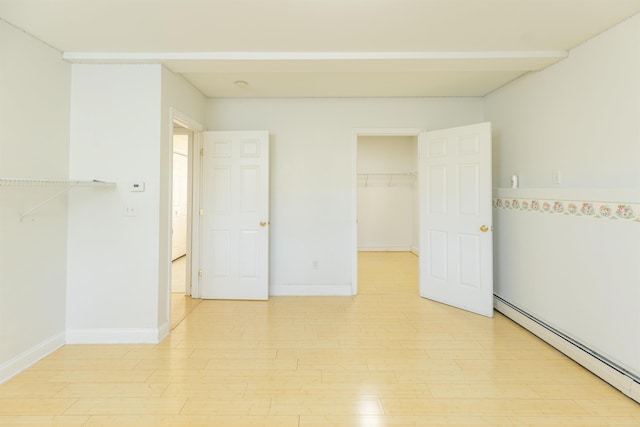 62 Indigo Hill Rd, Somersworth, NH 03878 - unfurnished bedroom with a baseboard radiator, a spacious closet, light wood-type flooring, a closet, and baseboards