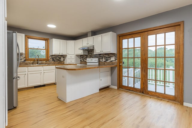 62 Indigo Hill Rd, Somersworth, NH 03878 - kitchen featuring white range with electric stovetop, freestanding refrigerator, a sink, under cabinet range hood, and a peninsula