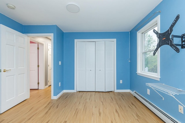 62 Indigo Hill Rd, Somersworth, NH 03878 - unfurnished bedroom featuring baseboard heating, baseboards, light wood-style flooring, and a closet