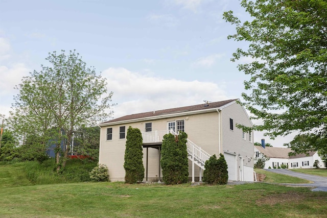 62 Indigo Hill Rd, Somersworth, NH 03878 - rear view of house featuring a garage, asphalt driveway, and a yard