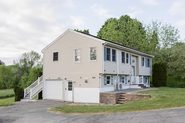 62 Indigo Hill Rd, Somersworth, NH 03878 - view of front of home with an attached garage, a cooling unit, asphalt driveway, a front yard, and stairway