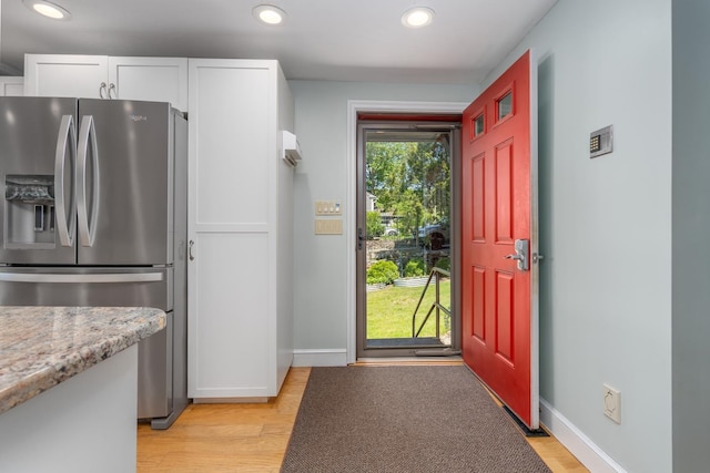 26 Association Dr, Northwood, NH 03261 - kitchen with stainless steel fridge with ice dispenser, white cabinetry, recessed lighting, light wood-type flooring, and baseboards