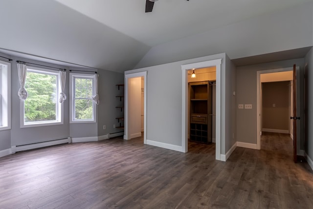 11 Rabbit Ln, Barrington, NH 03825 - unfurnished bedroom featuring a baseboard radiator, lofted ceiling, dark wood-style floors, a walk in closet, and baseboards