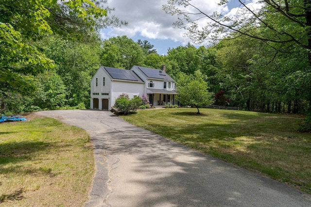 11 Rabbit Ln, Barrington, NH 03825 - view of front of house with a porch, driveway, a chimney, a front yard, and roof mounted solar panels