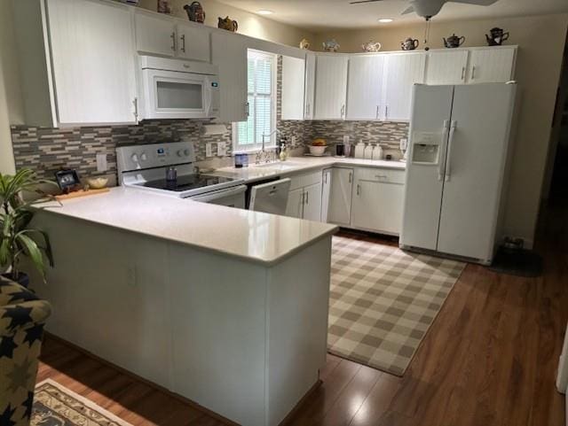 3 Dove St, Wolfeboro, NH 03894 - kitchen with white appliances, light countertops, a peninsula, a sink, and backsplash