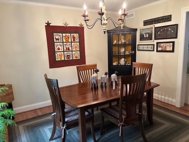 3 Dove St, Wolfeboro, NH 03894 - dining area featuring a chandelier, ornamental molding, wood finished floors, and baseboards