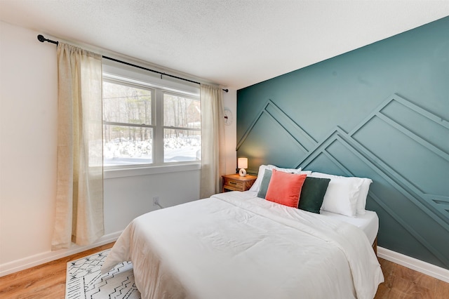 270 Beechnut Dr, Conway, NH 03860 - bedroom featuring baseboards, light wood-type flooring, and a textured ceiling