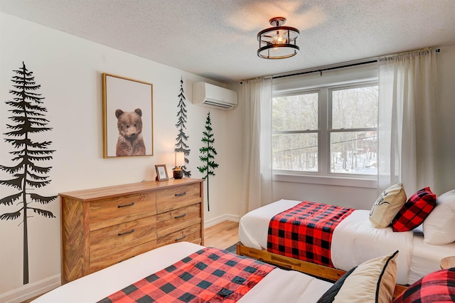 270 Beechnut Dr, Conway, NH 03860 - bedroom with a wall mounted AC, light wood-style flooring, and a textured ceiling