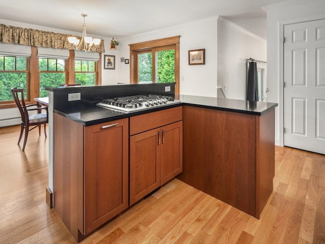 278 S Cove Rd, Burlington, VT 05401 - kitchen with stainless steel gas stovetop, dark countertops, brown cabinets, light wood-style floors, and ornamental molding