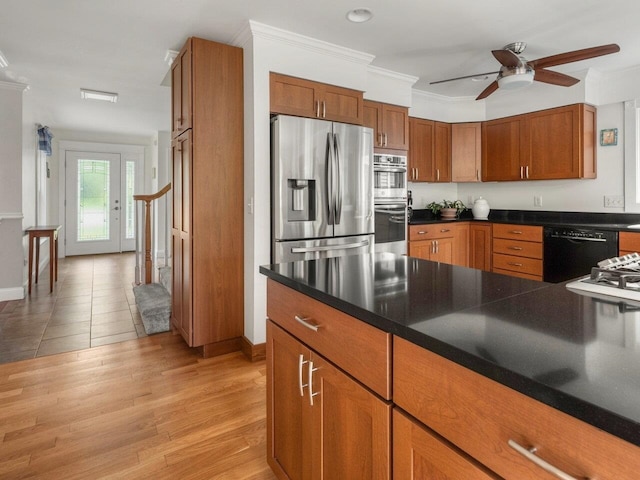278 S Cove Rd, Burlington, VT 05401 - kitchen featuring stainless steel appliances, brown cabinetry, a ceiling fan, dark countertops, and ornamental molding